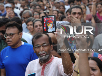 Doctors and citizens hold placards while marching with burning torches during a protest march and shout slogans, protesting against the rape...