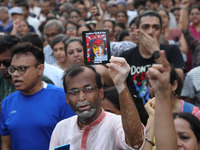 Doctors and citizens hold placards while marching with burning torches during a protest march and shout slogans, protesting against the rape...