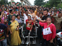 A handicapped man shouts slogans and holds a burning torch while doctors and citizens hold placards and march with burning torches during a...