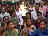 Doctors and citizens hold placards while marching with burning torches during a protest march and shout slogans, protesting against the rape...