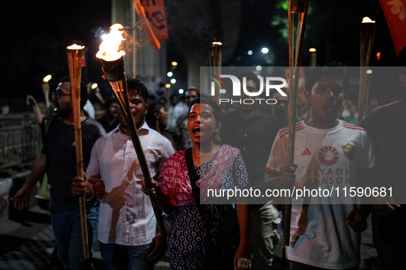 People hold a procession with torches to protest the recent violent clashes and counter-clashes between the local indigenous population and...