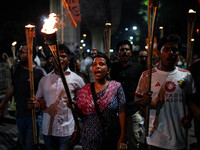 People hold a procession with torches to protest the recent violent clashes and counter-clashes between the local indigenous population and...