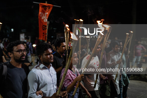 People hold a procession with torches to protest the recent violent clashes and counter-clashes between the local indigenous population and...