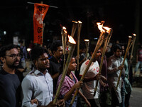 People hold a procession with torches to protest the recent violent clashes and counter-clashes between the local indigenous population and...