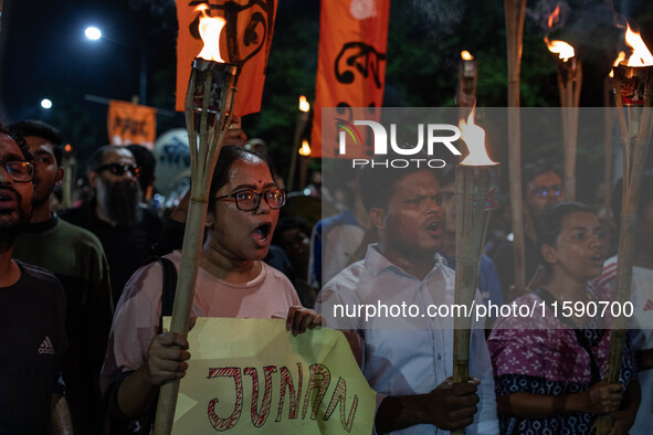 People hold a procession with torches to protest the recent violent clashes and counter-clashes between the local indigenous population and...