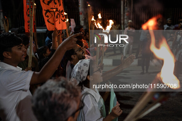 People hold a procession with torches to protest the recent violent clashes and counter-clashes between the local indigenous population and...