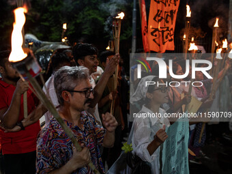 People hold a procession with torches to protest the recent violent clashes and counter-clashes between the local indigenous population and...