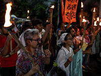 People hold a procession with torches to protest the recent violent clashes and counter-clashes between the local indigenous population and...