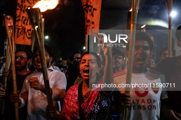 People hold a procession with torches to protest the recent violent clashes and counter-clashes between the local indigenous population and...