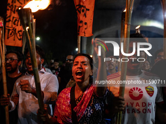 People hold a procession with torches to protest the recent violent clashes and counter-clashes between the local indigenous population and...