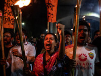 People hold a procession with torches to protest the recent violent clashes and counter-clashes between the local indigenous population and...