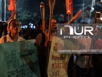 People hold a procession with torches to protest the recent violent clashes and counter-clashes between the local indigenous population and...