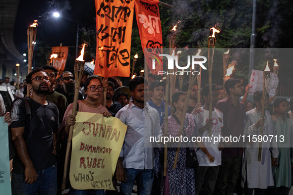 People hold a procession with torches to protest the recent violent clashes and counter-clashes between the local indigenous population and...