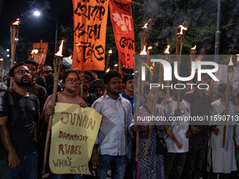 People hold a procession with torches to protest the recent violent clashes and counter-clashes between the local indigenous population and...