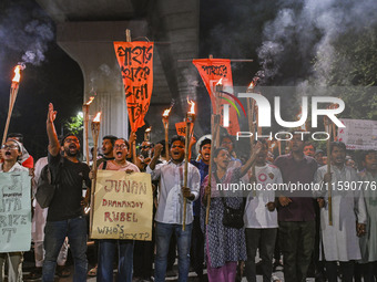 Activists and protesters hold a torch march in Dhaka, Bangladesh, on September 20, 2024. They demand the arrest and trial of those involved...