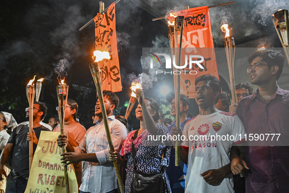 Activists and protesters hold a torch march in Dhaka, Bangladesh, on September 20, 2024. They demand the arrest and trial of those involved...