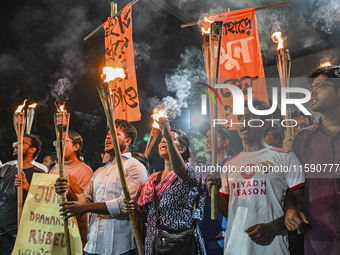 Activists and protesters hold a torch march in Dhaka, Bangladesh, on September 20, 2024. They demand the arrest and trial of those involved...