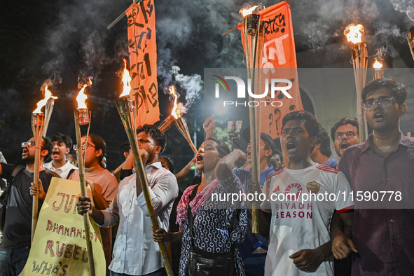 Activists and protesters hold a torch march in Dhaka, Bangladesh, on September 20, 2024. They demand the arrest and trial of those involved...