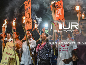 Activists and protesters hold a torch march in Dhaka, Bangladesh, on September 20, 2024. They demand the arrest and trial of those involved...