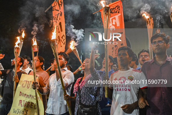 Activists and protesters hold a torch march in Dhaka, Bangladesh, on September 20, 2024. They demand the arrest and trial of those involved...