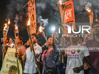 Activists and protesters hold a torch march in Dhaka, Bangladesh, on September 20, 2024. They demand the arrest and trial of those involved...