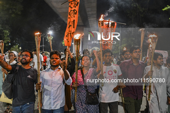 Activists and protesters hold a torch march in Dhaka, Bangladesh, on September 20, 2024. They demand the arrest and trial of those involved...