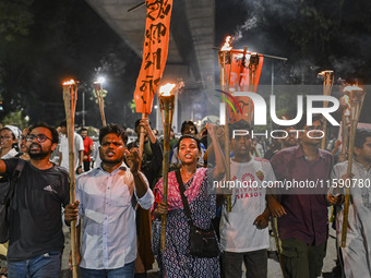 Activists and protesters hold a torch march in Dhaka, Bangladesh, on September 20, 2024. They demand the arrest and trial of those involved...