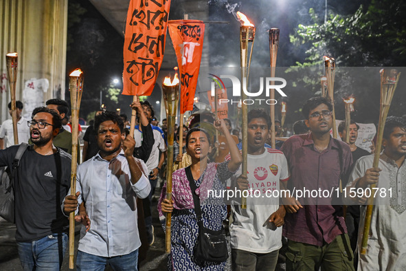 Activists and protesters hold a torch march in Dhaka, Bangladesh, on September 20, 2024. They demand the arrest and trial of those involved...