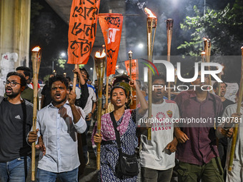 Activists and protesters hold a torch march in Dhaka, Bangladesh, on September 20, 2024. They demand the arrest and trial of those involved...