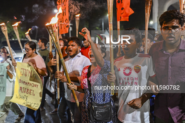 Activists and protesters hold a torch march in Dhaka, Bangladesh, on September 20, 2024. They demand the arrest and trial of those involved...