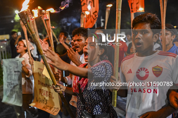 Activists and protesters hold a torch march in Dhaka, Bangladesh, on September 20, 2024. They demand the arrest and trial of those involved...