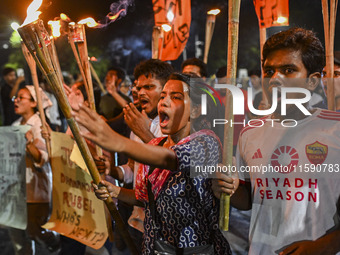 Activists and protesters hold a torch march in Dhaka, Bangladesh, on September 20, 2024. They demand the arrest and trial of those involved...