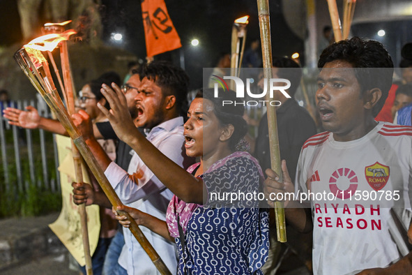 Activists and protesters hold a torch march in Dhaka, Bangladesh, on September 20, 2024. They demand the arrest and trial of those involved...