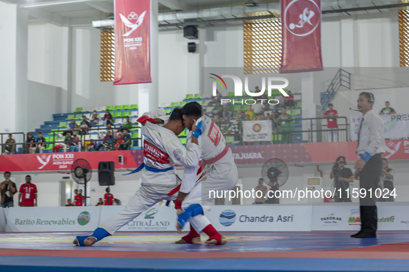 Jiu-jitsu athlete from North Sumatra, Raihan Syauqi (blue), competes against Frederikus Karubun, an athlete from the Central Papua contingen...