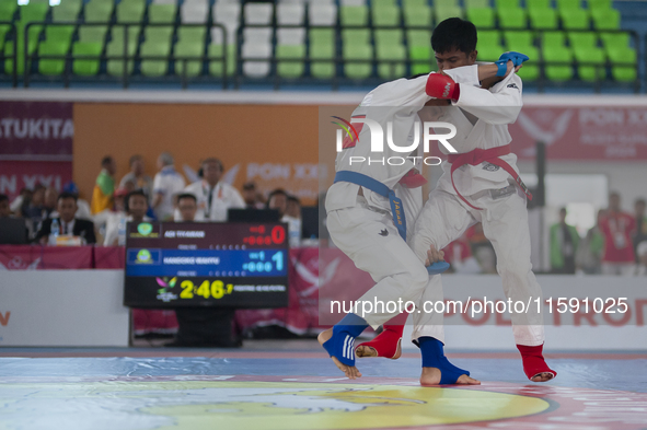 Adi Tiyawan, an East Kalimantan Jiu-jitsu athlete (Red), and Handoko Wahyu (Blue) from the West Java contingent fight in the Men's -62 KG Fi...