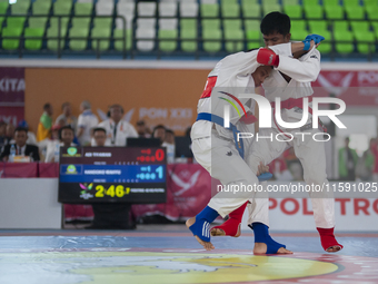 Adi Tiyawan, an East Kalimantan Jiu-jitsu athlete (Red), and Handoko Wahyu (Blue) from the West Java contingent fight in the Men's -62 KG Fi...