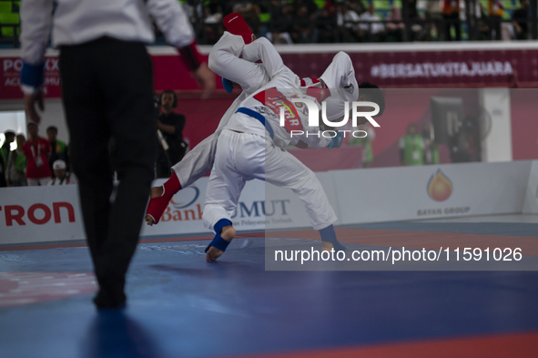 Adi Tiyawan, an East Kalimantan Jiu-jitsu athlete (Red), and Handoko Wahyu (Blue) from the West Java contingent compete in the Men's -62 KG...