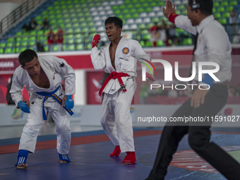 Adi Tiyawan, an East Kalimantan Jiu-jitsu athlete (Red), and Handoko Wahyu (Blue) from the West Java contingent compete in the Men's -62 KG...