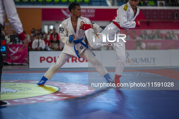 Aceh Province Ju-Jitsu athlete Aldo Afriansyah competes against Central Java Ju-Jitsu athlete Yulianto (Blue) in the men's fighting system -...