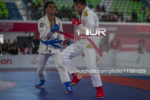 Aceh Province Ju-Jitsu athlete Aldo Afriansyah competes against Central Java Ju-Jitsu athlete Yulianto (Blue) in the men's fighting system -...