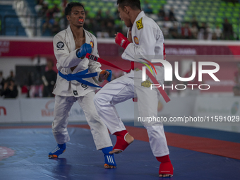 Aceh Province Ju-Jitsu athlete Aldo Afriansyah competes against Central Java Ju-Jitsu athlete Yulianto (Blue) in the men's fighting system -...