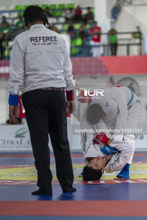 East Java Jiu-jitsu athlete Artz Brilliant Perfecto (Red) competes against North Sumatra contingent athlete Ronaldo Sagala (Blue) in the Fig...