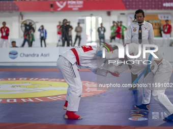 East Java Jiu-jitsu athlete Artz Brilliant Perfecto (Red) competes against North Sumatra contingent athlete Ronaldo Sagala (Blue) in the Fig...