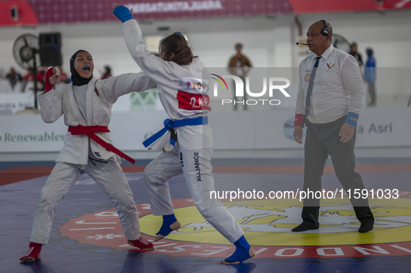 Central Java Jiu-jitsu athlete Tria Novita Sari (Red) competes against female athlete Tiffany Sie from the DKI Jakarta contingent in the Wom...