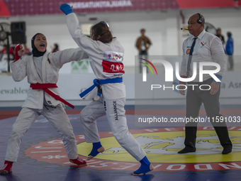 Central Java Jiu-jitsu athlete Tria Novita Sari (Red) competes against female athlete Tiffany Sie from the DKI Jakarta contingent in the Wom...