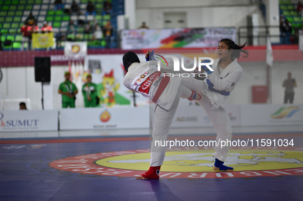 Female Jiu-Jitsu athlete from North Sumatra (Red), Suci Anggi Harum, competes against West Java contingent athlete, Octi Putri (Blue), in th...