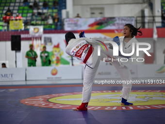 Female Jiu-Jitsu athlete from North Sumatra (Red), Suci Anggi Harum, competes against West Java contingent athlete, Octi Putri (Blue), in th...