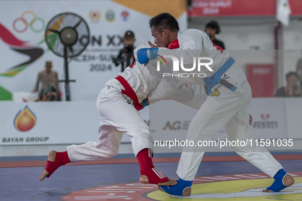 Aceh Jiu Jitsu athlete Aldo Alfriansyah (Blue) competes against an athlete from the West Java contingent, Handoko Wahyu (Red), in the men's...