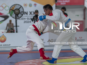 Aceh Jiu Jitsu athlete Aldo Alfriansyah (Blue) competes against an athlete from the West Java contingent, Handoko Wahyu (Red), in the men's...