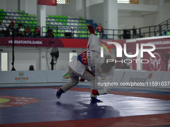 Linda Darrow, an Acehnese Jiu Jitsu athlete (Blue), competes against Tifanny Sie, an athlete from the DKI Jakarta contingent (Red), in the w...